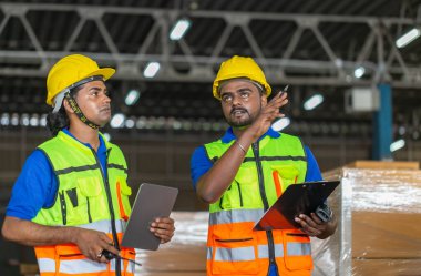 Workers team taking inventory in factory warehouse, Manual workers working in warehouse talking about job