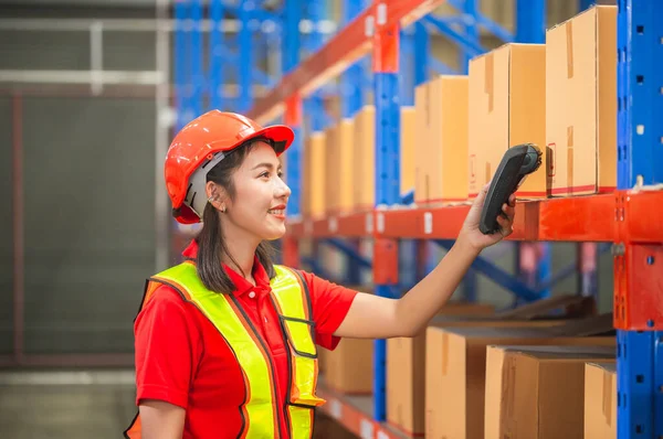 Warehouse worker with bar code scanner checking inventory, Female worker scanning boxes in warehouse rack, Workers working in warehouse