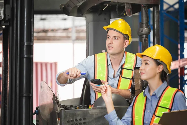 Manager and supervisor taking inventory in warehouse, Foreperson making plans with female warehouse, Workers working in warehouse