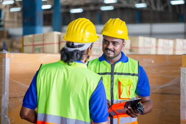 Selective focus workers team taking inventory in factory warehouse, Foreman workers working in warehouse talking about job