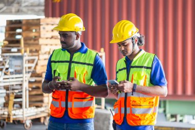 Warehouse worker in the hard hat uses mobile phone, Men using smartphone
