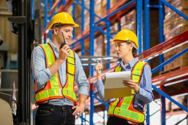 Workers working in warehouse, Manager and supervisor taking inventory in warehouse, Female foreperson making plans with warehousemen