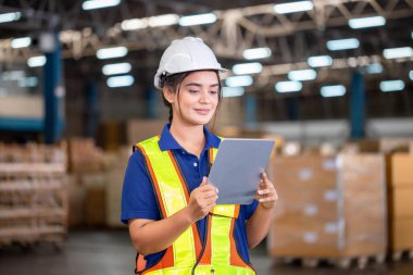Warehouse worker with digital tablet checking inventory in warehouse, Female warehouse worker working in factory warehouse
