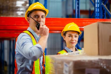 Müdür ve amir depoda envanter çıkarıyor, kadın ustabaşı depoda çalışan işçilerle plan yapıyor.