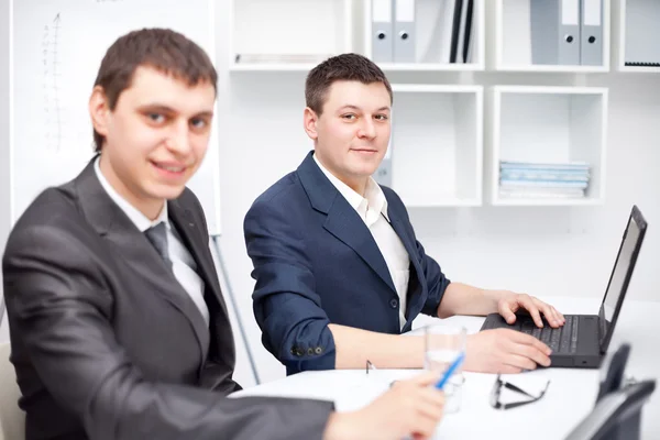 Két fiatal üzletember együtt dolgozik az irodában. — Stock Fotó