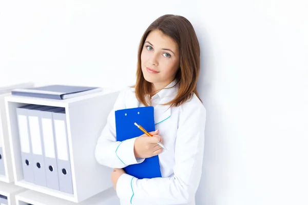 Retrato de una joven doctora sosteniendo portapapeles en el hospital — Foto de Stock