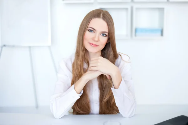 Retrato de hermosa joven mujer de negocios sentada en el escritorio en de —  Fotos de Stock
