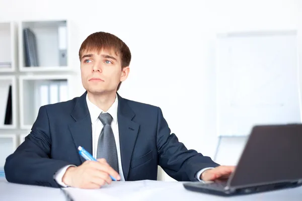 Retrato de un joven hombre de negocios sonriente escribiendo sobre papeleo en o —  Fotos de Stock