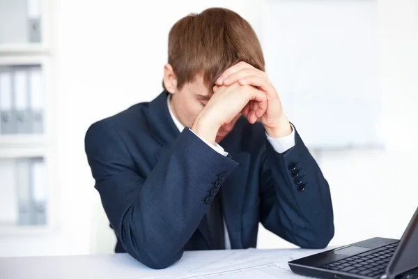 Müder junger Geschäftsmann mit Problemen und Stress im hellen Büro — Stockfoto