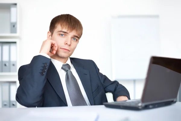 Jovem empresário trabalhando no laptop no escritório — Fotografia de Stock