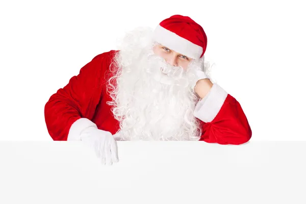 Santa Claus leaning on blank board isolated on white background Stock Picture