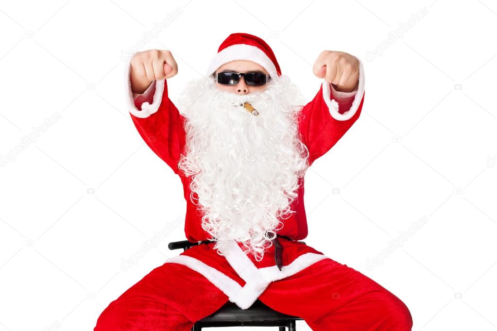 Man in Santa Claus clothes sitting in a chair wearing sunglasses