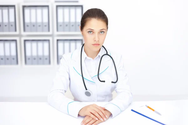 Young female doctor sitting at desk in hospital — Stock Photo, Image