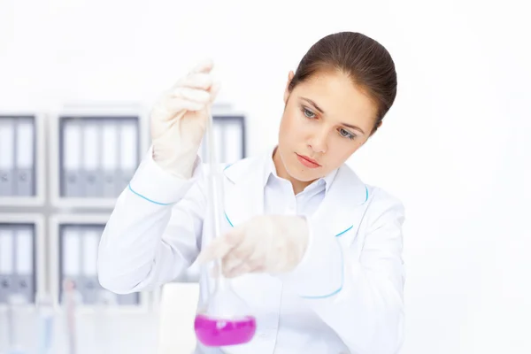 Joven investigadora química femenina que trabaja con productos químicos — Foto de Stock
