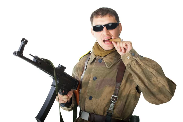 Soldier wearing sunglasses with machine gun smoking a cigar — Stock Photo, Image
