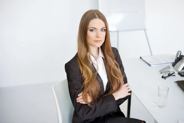 Retrato de bela jovem mulher de negócios sentado na mesa em de — Fotografia de Stock