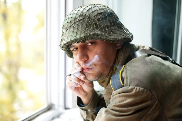 Soldado fumando cerca de la ventana — Foto de Stock