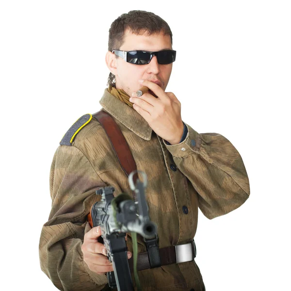 Soldat portant des lunettes de soleil avec mitrailleuse fumant un cigare — Photo