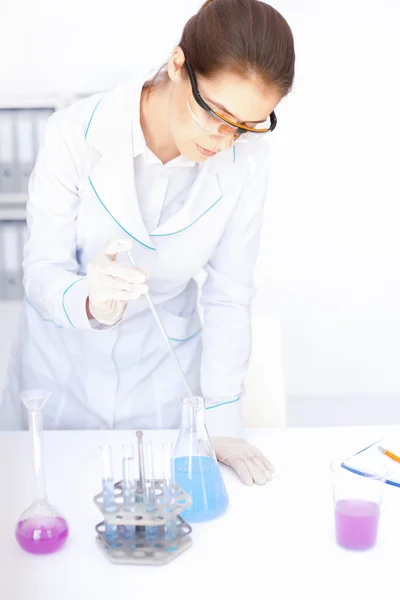 Jonge chemische vrouwelijke onderzoeker met flesjes en kolven — Stockfoto