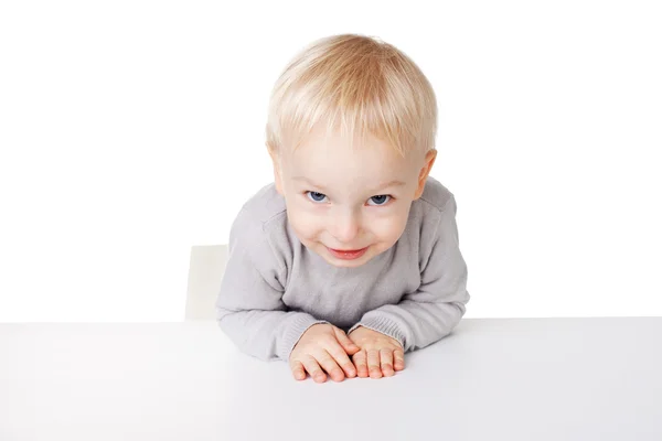 Kleiner Junge sitzt am Tisch — Stockfoto