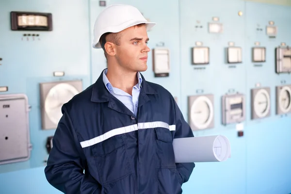 Ingeniero con casco y planos en la sala de control — Foto de Stock