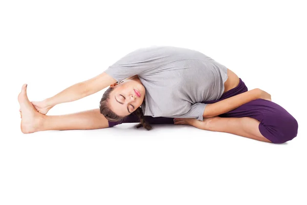 Mladá žena dělá jóga cvičení izolované na bílém — Stock fotografie