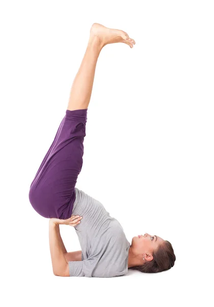 Jonge vrouw doen yoga oefening ondersteund shoulderstand — Stockfoto