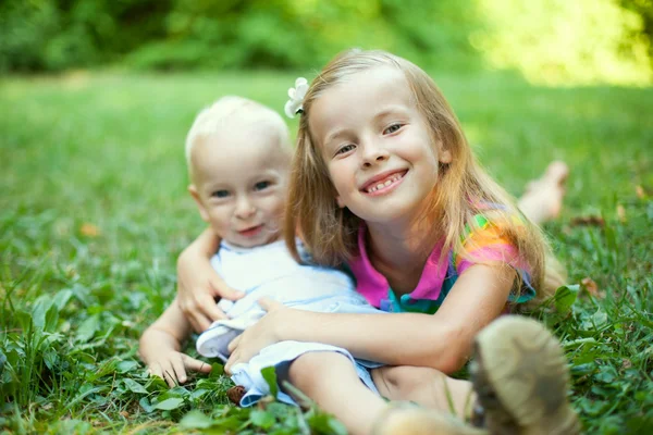 Sorella e fratello sdraiati sull'erba verde — Foto Stock