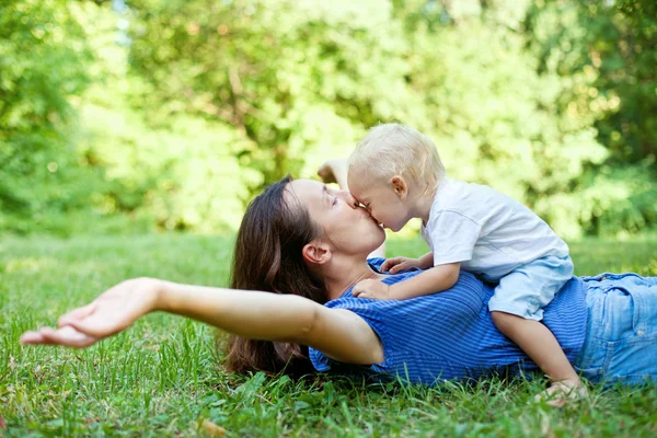 Madre e figlio si divertono sull'erba nel parco — Foto Stock