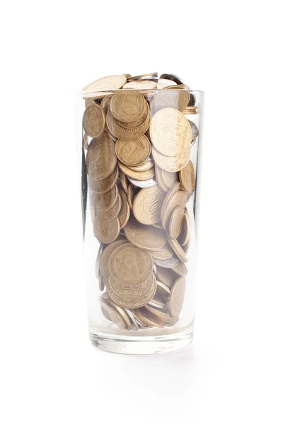 Monedas en una taza de vidrio aislada en blanco — Foto de Stock