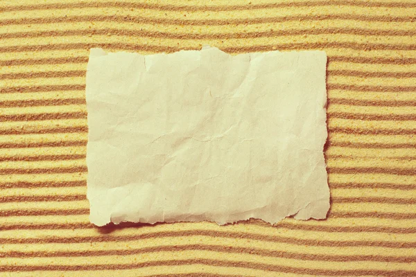 Bílý list papíru na písku — Stock fotografie