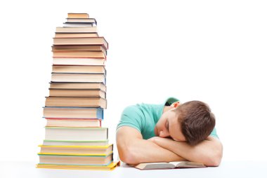 Uyuyan öğrenci yüksek kitap yığını ile masaya oturan