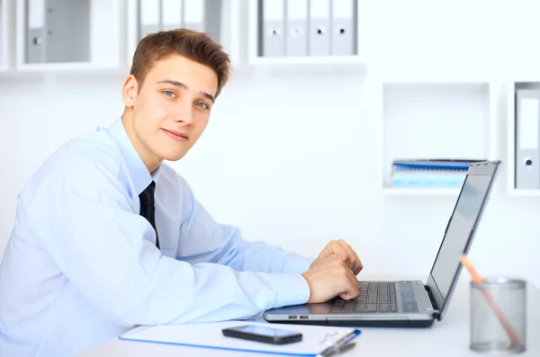 在笔记本电脑上工作的年轻微笑商人 — 图库照片