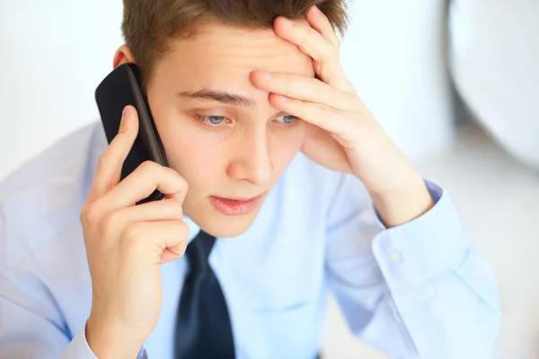 Joven empresario pensativo hablando por teléfono celular —  Fotos de Stock