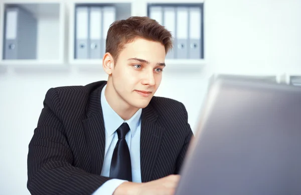 Jovem empresário trabalhando no laptop no escritório — Fotografia de Stock