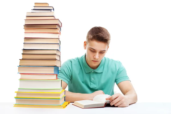 Estudante estudando em uma mesa com uma pilha de livros — Fotografia de Stock