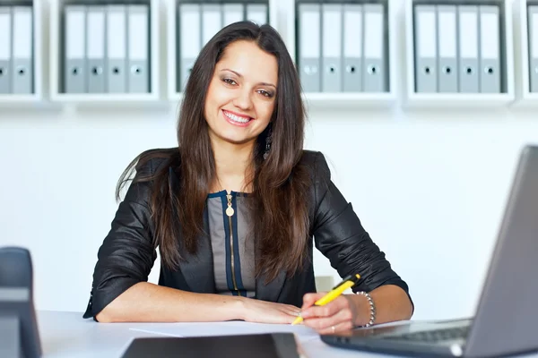 Giovane donna d'affari sorridente alla scrivania dell'ufficio — Foto Stock