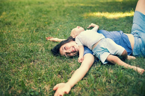 Anne ve oğlu çimlere eğleniyor — Stok fotoğraf