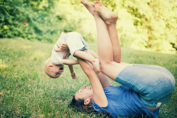 Mãe e filho se divertindo na grama — Fotografia de Stock