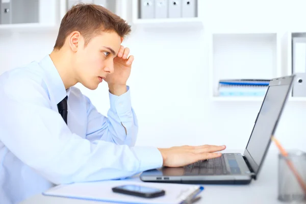 Jeune homme d'affaires travaillant sur ordinateur portable dans le bureau — Photo