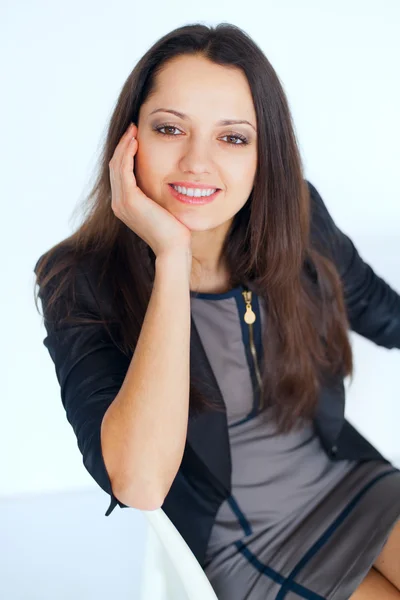 Young smiling brunette business woman sitting on a chair — Stock Photo, Image