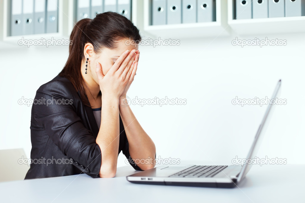 Tired young business woman with laptop