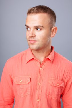 gri arka plan üzerinde kırmızı bir gömlek giymiş genç adam