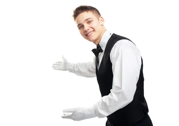Junger fröhlich lächelnder Kellner gestikuliert zur Begrüßung — Stockfoto