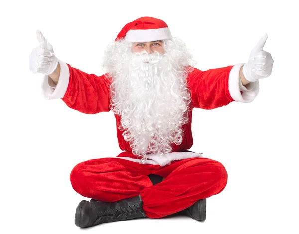 Jultomten som sitter på golvet med tummen upp skylt — Stock fotografie