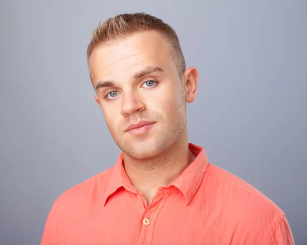 Junger Mann mit rotem Hemd auf grauem Hintergrund — Stockfoto