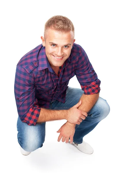 Portrait of smiling young man squatting — Stock Photo, Image