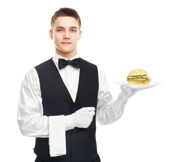 Молодий усміхнений офіціант тримає бургер на тарілці — стокове фото