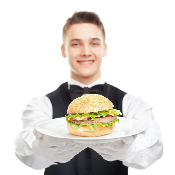 Jonge gelukkig lachend ober houden hamburger op plaat — Stockfoto