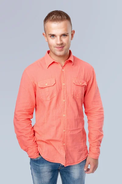 Joven vistiendo una camisa roja sobre fondo gris —  Fotos de Stock